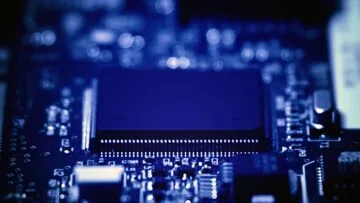Close-up photograph of a processor and electronic components on a blue circuit board