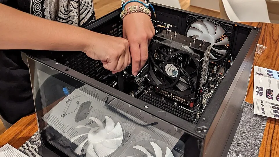 Person working inside a desktop PC, illustrating graphics-driver and game performance troubleshooting